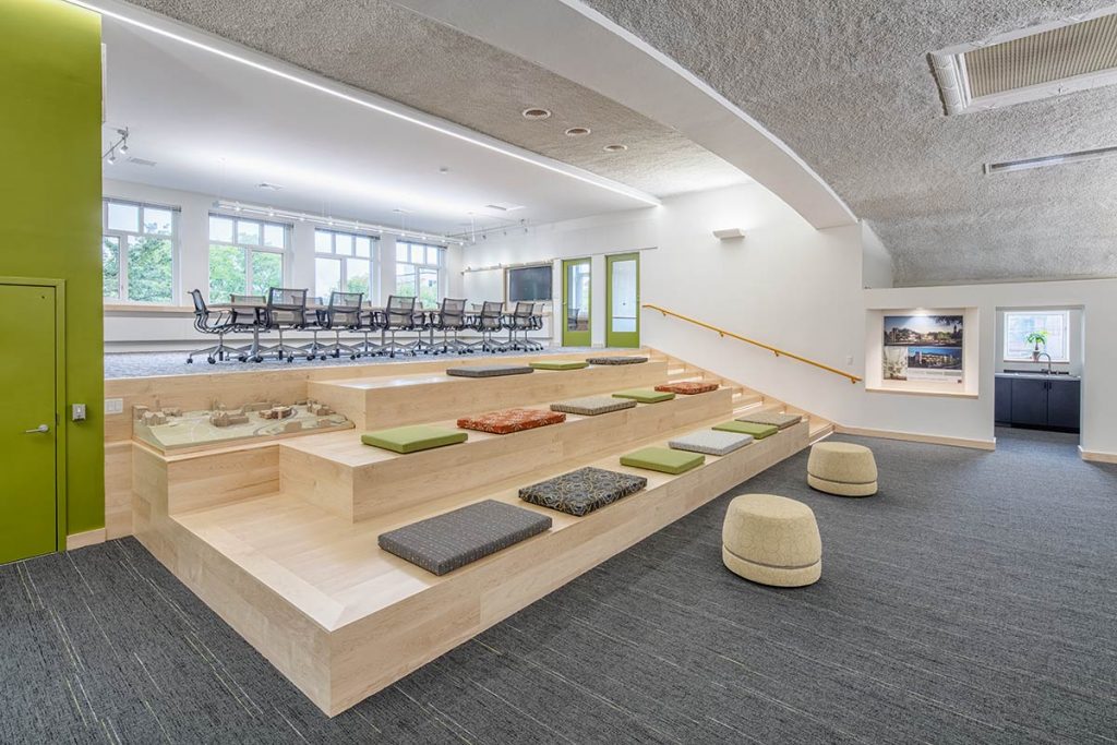 unique and colorful office gathering area with tiered seating and conference table in historic building